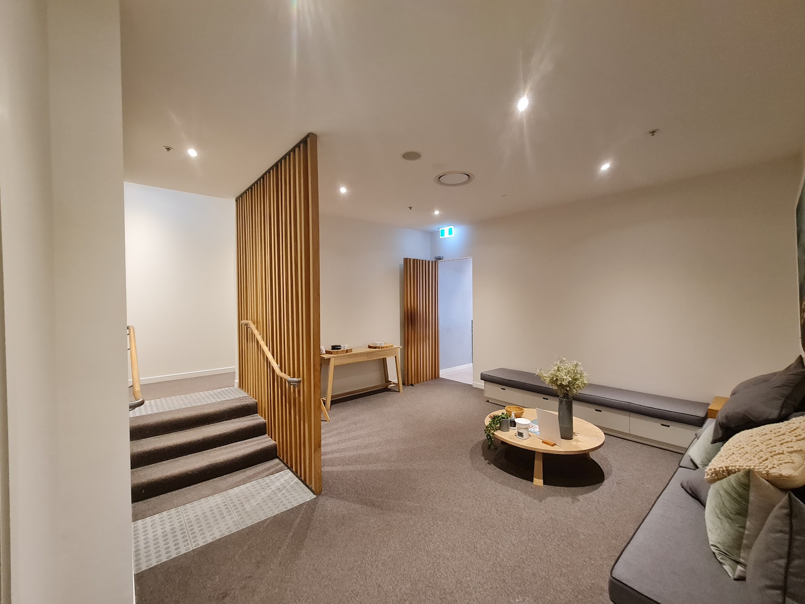 Freshly painted living area with a timber batten screen beside the stairs